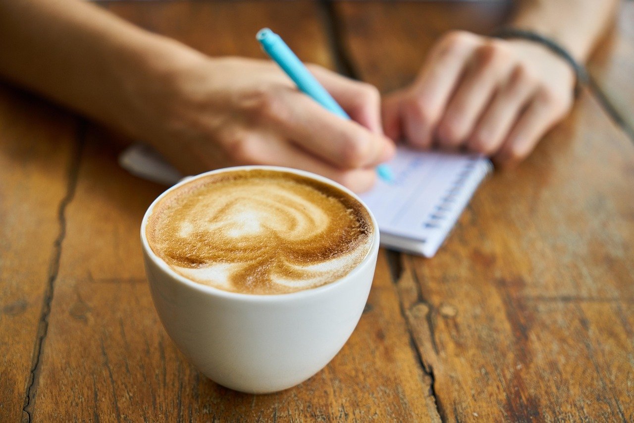coffee cup beside laptop